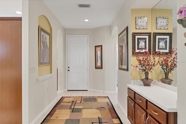 4121 Reflections Pkwy, Sarasota, FL 34233 - foyer featuring arched walkways, light tile patterned floors, baseboards, and recessed lighting