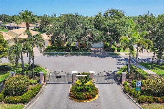 4121 Reflections Pkwy, Sarasota, FL 34233 - view of asphalt road with a gate, a gated entry, and curbs