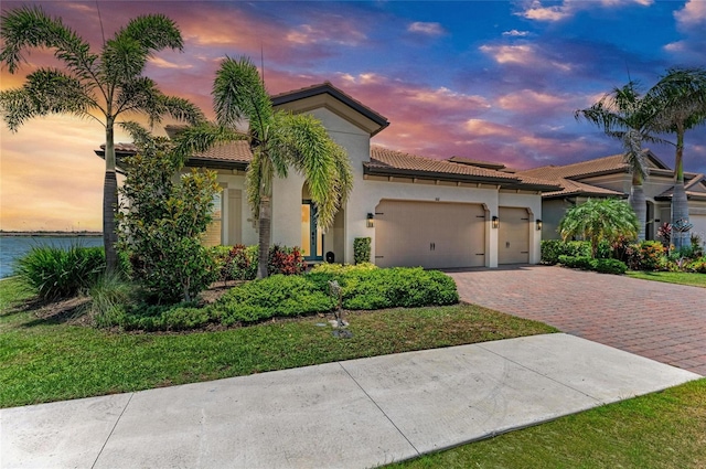 501 Maraviya Blvd, Nokomis, FL 34275 - mediterranean / spanish house featuring driveway, an attached garage, stucco siding, and a tile roof