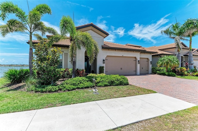 501 Maraviya Blvd, Nokomis, FL 34275 - mediterranean / spanish-style home with an attached garage, stucco siding, decorative driveway, and a tiled roof