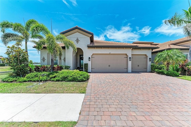 501 Maraviya Blvd, Nokomis, FL 34275 - mediterranean / spanish-style house featuring stucco siding, an attached garage, decorative driveway, and a tiled roof