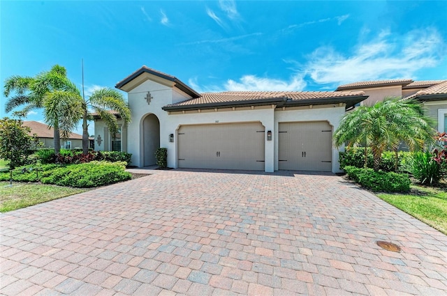 501 Maraviya Blvd, Nokomis, FL 34275 - mediterranean / spanish-style house with decorative driveway, stucco siding, a tiled roof, and a garage