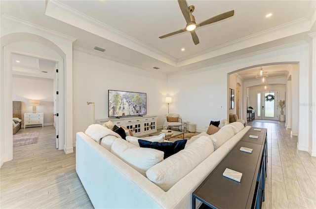 501 Maraviya Blvd, Nokomis, FL 34275 - living area with arched walkways, a ceiling fan, a tray ceiling, crown molding, and baseboards
