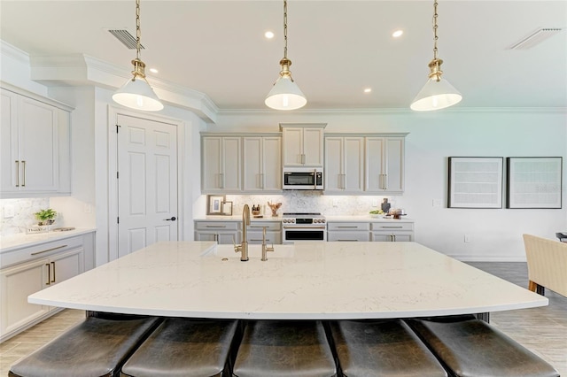 501 Maraviya Blvd, Nokomis, FL 34275 - kitchen featuring range, stainless steel microwave, a sink, a breakfast bar, and decorative backsplash