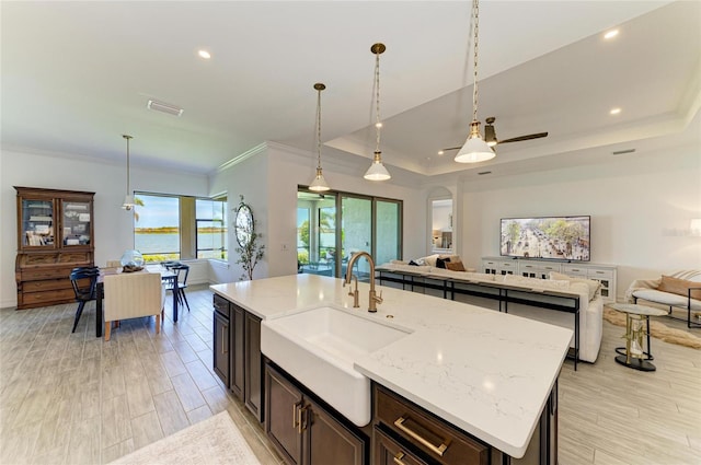 501 Maraviya Blvd, Nokomis, FL 34275 - kitchen featuring open floor plan, a sink, ornamental molding, a kitchen island with sink, and recessed lighting