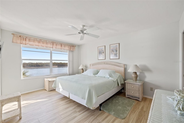 4310 Falmouth Dr Unit 307, Longboat Key, FL 34228 - bedroom with light wood-style flooring, baseboards, a water view, and ceiling fan