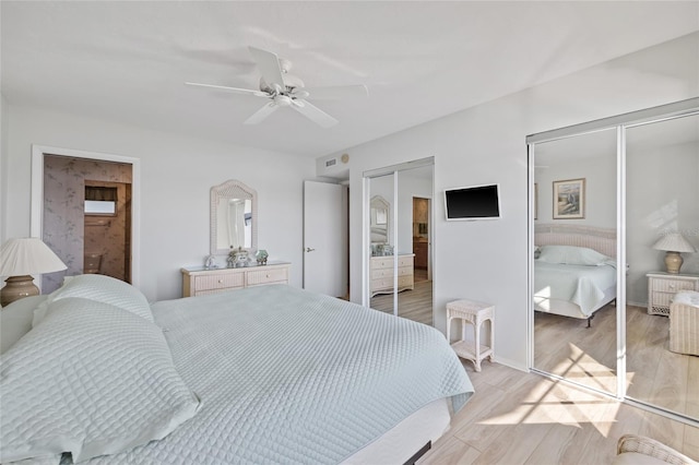4310 Falmouth Dr Unit 307, Longboat Key, FL 34228 - bedroom with multiple closets, light wood-style floors, a ceiling fan, and baseboards