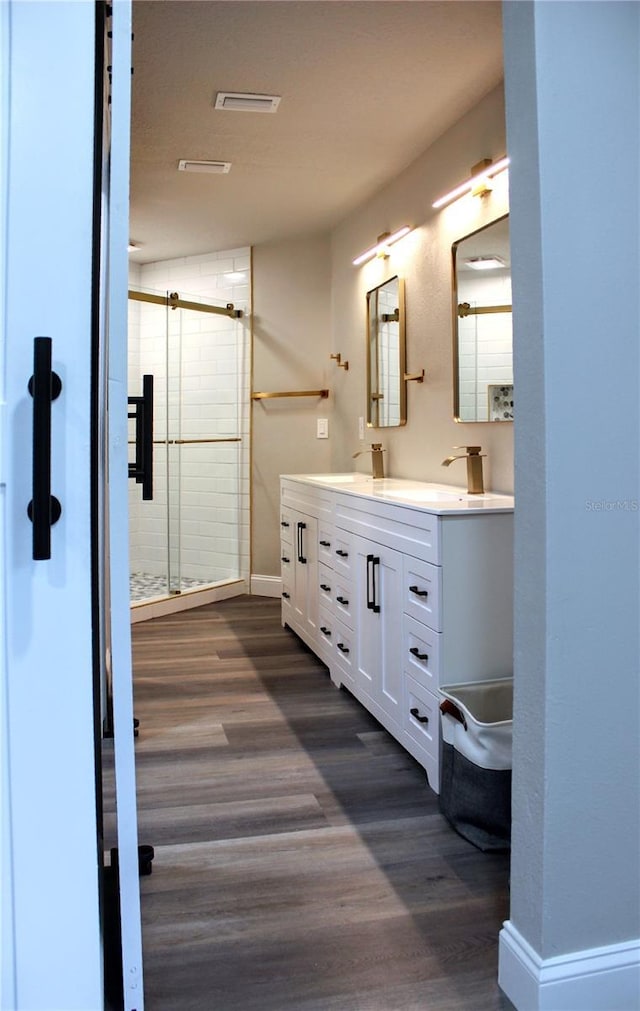 27944 Green Willow Run, Wesley Chapel, FL 33544 - full bath with double vanity, a shower stall, wood finished floors, and baseboards