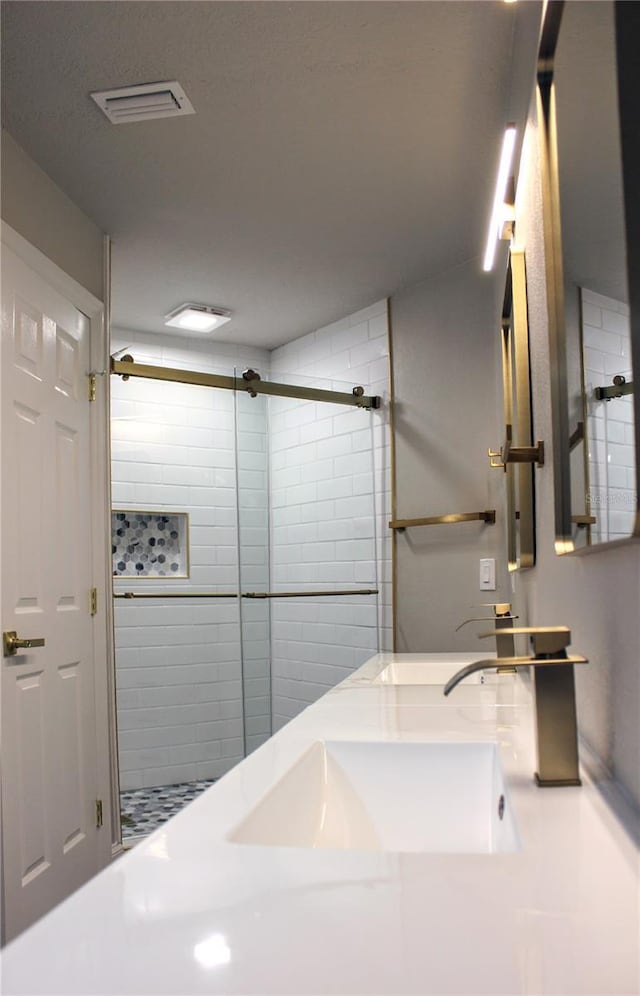 27944 Green Willow Run, Wesley Chapel, FL 33544 - bathroom with a tile shower and double vanity
