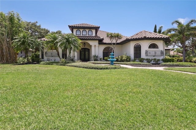4696 Del Sol Blvd, Sarasota, FL 34243 - mediterranean / spanish-style house with a front lawn, stucco siding, french doors, and a tile roof
