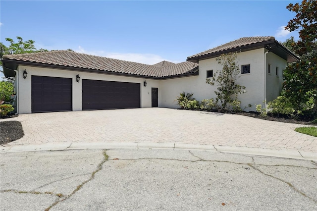 4696 Del Sol Blvd, Sarasota, FL 34243 - mediterranean / spanish home with a garage, stucco siding, driveway, and a tile roof