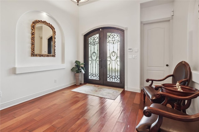 4696 Del Sol Blvd, Sarasota, FL 34243 - foyer entrance with french doors, wood finished floors, baseboards, and arched walkways