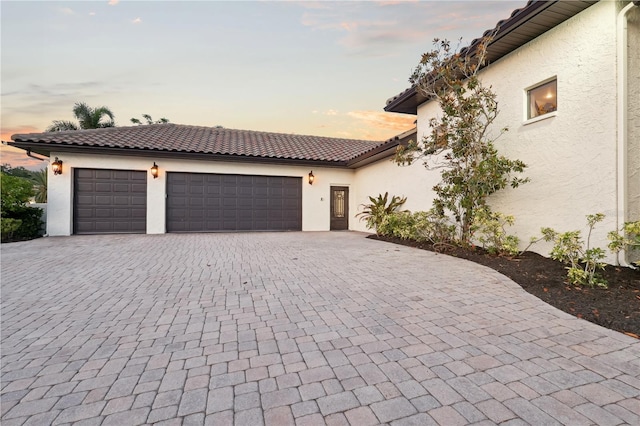 4696 Del Sol Blvd, Sarasota, FL 34243 - view of front of home with stucco siding, decorative driveway, and a garage