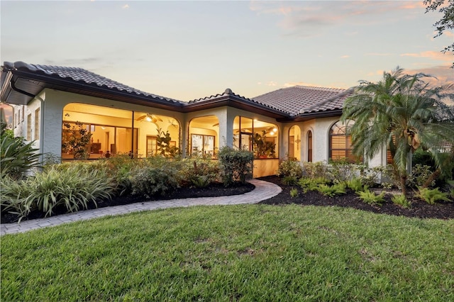 4696 Del Sol Blvd, Sarasota, FL 34243 - rear view of property featuring a lawn, stucco siding, and a tile roof
