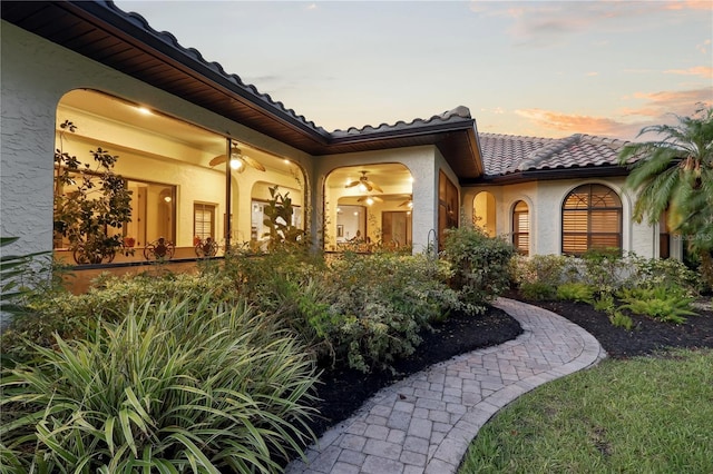 4696 Del Sol Blvd, Sarasota, FL 34243 - back of property at dusk featuring stucco siding and a tiled roof