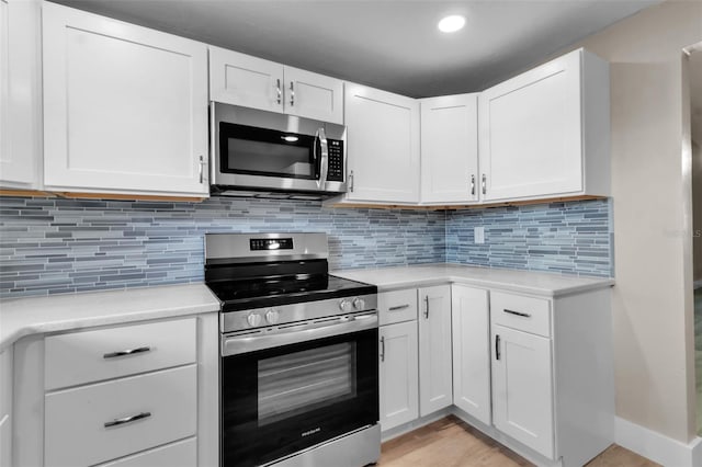 1409 57th St W Unit 1409, Bradenton, FL 34209 - kitchen with stainless steel appliances, light countertops, white cabinets, baseboards, and recessed lighting