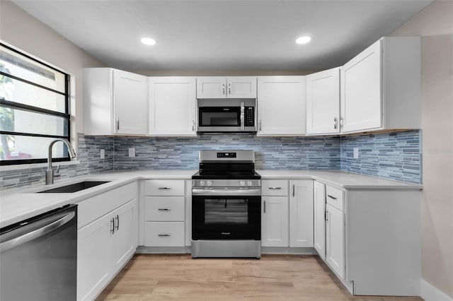 1409 57th St W Unit 1409, Bradenton, FL 34209 - kitchen featuring appliances with stainless steel finishes, light countertops, white cabinets, light wood-type flooring, and recessed lighting