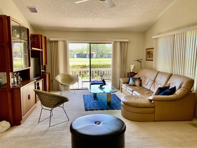 3407 Avenida Madera Unit A, Bradenton, FL 34210 - living room featuring carpet floors, a textured ceiling, vaulted ceiling, and ceiling fan