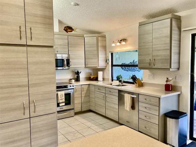 3407 Avenida Madera Unit A, Bradenton, FL 34210 - kitchen featuring appliances with stainless steel finishes, a sink, a textured ceiling, light countertops, and light tile patterned floors