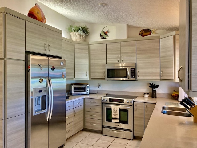 3407 Avenida Madera Unit A, Bradenton, FL 34210 - kitchen with stainless steel appliances, a textured ceiling, a sink, light countertops, and light tile patterned floors