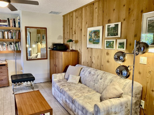 3407 Avenida Madera Unit A, Bradenton, FL 34210 - living room featuring wooden walls, ceiling fan, wood finished floors, and a textured ceiling