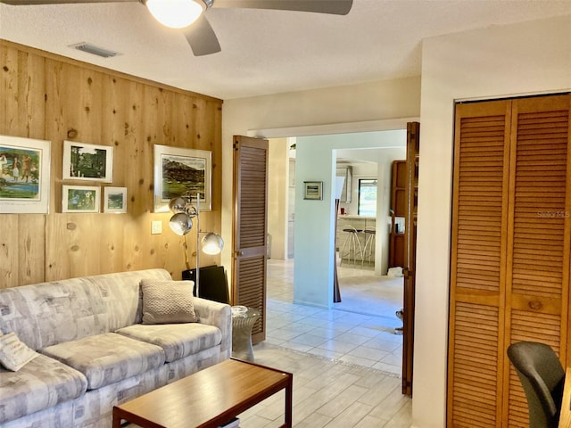 3407 Avenida Madera Unit A, Bradenton, FL 34210 - living area featuring ceiling fan, wood walls, and light wood-type flooring