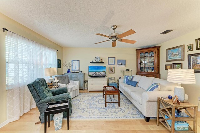 1906 Canterbury Ln Unit 16, Sun City Center, FL 33573 - living area featuring ceiling fan, light wood-type flooring, and a textured ceiling