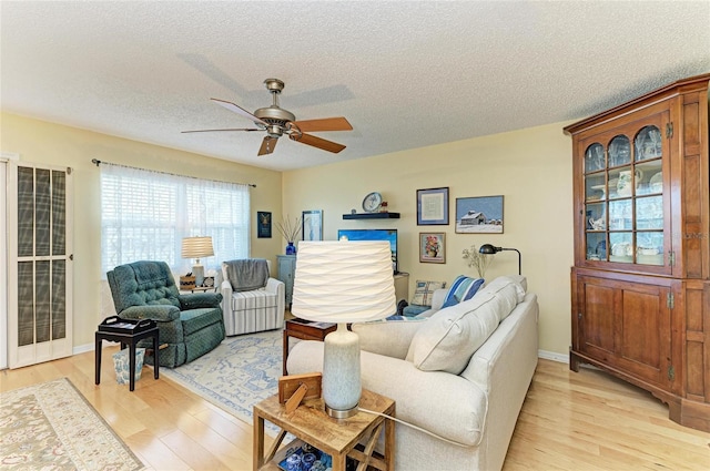 1906 Canterbury Ln Unit 16, Sun City Center, FL 33573 - living area featuring light wood-style floors, ceiling fan, and a textured ceiling