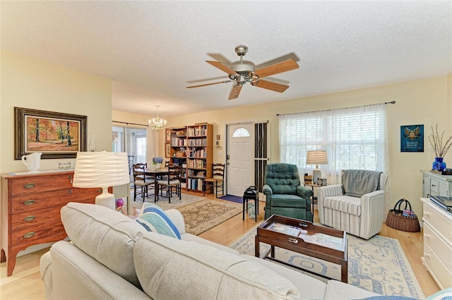 1906 Canterbury Ln Unit 16, Sun City Center, FL 33573 - living area with light wood-style flooring, a ceiling fan, a chandelier, and a textured ceiling