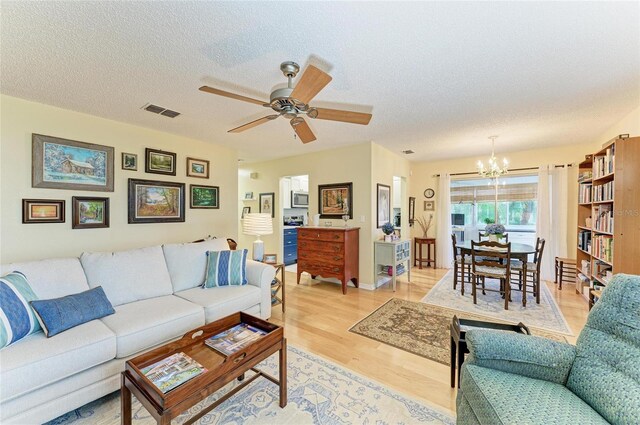 1906 Canterbury Ln Unit 16, Sun City Center, FL 33573 - living area with a chandelier, light wood-style floors, a textured ceiling, and a ceiling fan