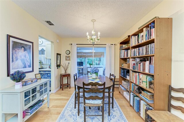 1906 Canterbury Ln Unit 16, Sun City Center, FL 33573 - dining area featuring a chandelier, a textured ceiling, and light wood-type flooring