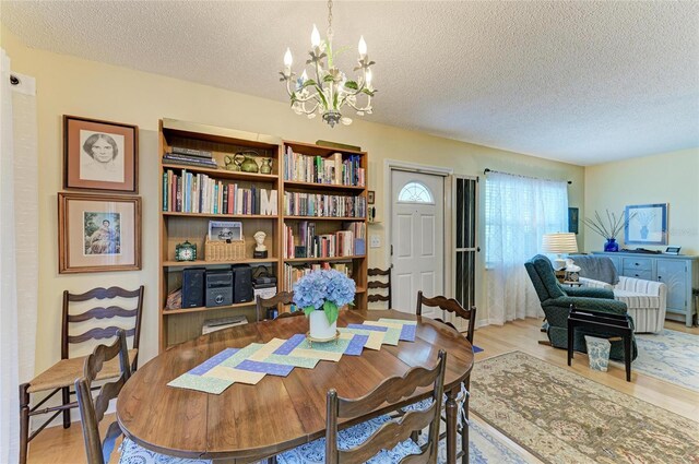 1906 Canterbury Ln Unit 16, Sun City Center, FL 33573 - dining room featuring a textured ceiling, a chandelier, and light wood finished floors