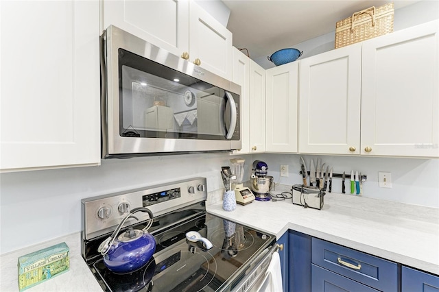 1906 Canterbury Ln Unit 16, Sun City Center, FL 33573 - kitchen with appliances with stainless steel finishes, light countertops, blue cabinets, and white cabinetry