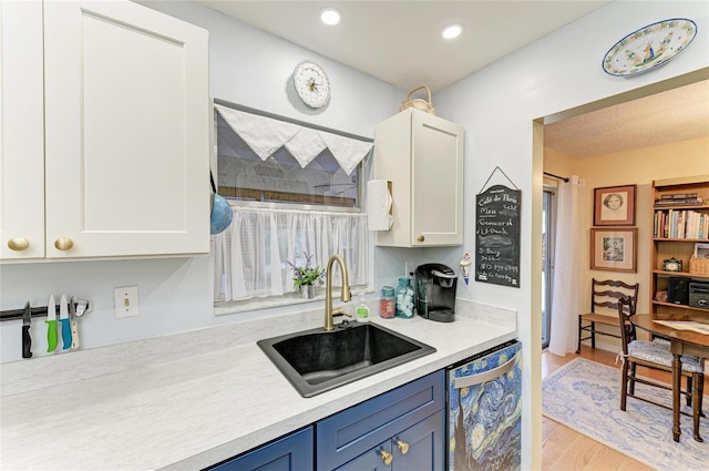 1906 Canterbury Ln Unit 16, Sun City Center, FL 33573 - kitchen with a sink, dishwasher, light countertops, blue cabinetry, and light wood finished floors