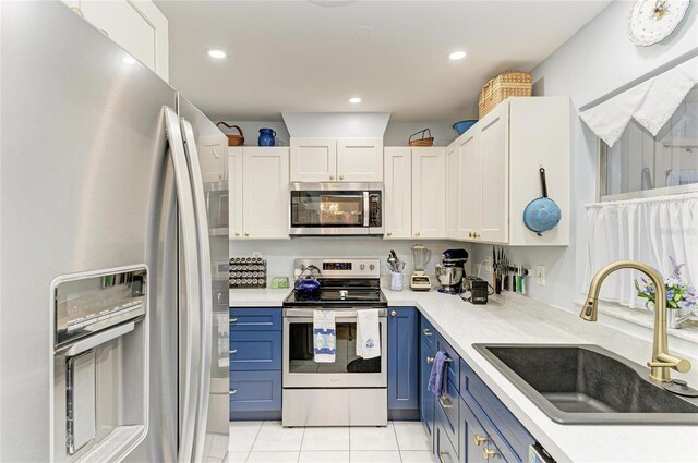 1906 Canterbury Ln Unit 16, Sun City Center, FL 33573 - kitchen featuring stainless steel appliances, blue cabinets, a sink, light tile patterned flooring, and light countertops