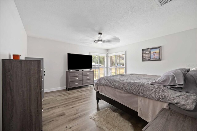 2255 61st St, Sarasota, FL 34243 - bedroom featuring wood finished floors, baseboards, a ceiling fan, and a textured ceiling