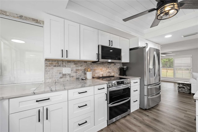 2255 61st St, Sarasota, FL 34243 - kitchen with appliances with stainless steel finishes, ceiling fan, light wood-style floors, tasteful backsplash, and light stone countertops