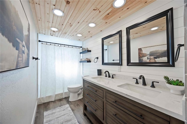2255 61st St, Sarasota, FL 34243 - bathroom featuring double vanity, recessed lighting, toilet, wood finished floors, and a shower with curtain