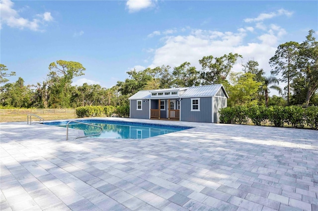 2255 61st St, Sarasota, FL 34243 - outdoor pool featuring a storage structure, a patio area, an outdoor structure, and view of wooded area