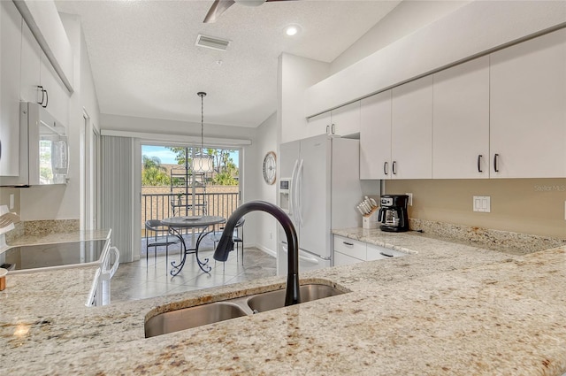 9540 High Gate Dr Unit 1422, Sarasota, FL 34238 - kitchen with white appliances, a sink, light stone countertops, ceiling fan, and white cabinetry
