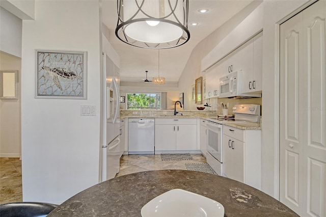 9540 High Gate Dr Unit 1422, Sarasota, FL 34238 - kitchen with white appliances, a sink, light stone counters, white cabinetry, and lofted ceiling