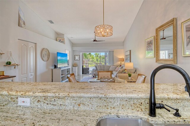 9540 High Gate Dr Unit 1422, Sarasota, FL 34238 - kitchen featuring lofted ceiling, a chandelier, a sink, light stone counters, and pendant lighting