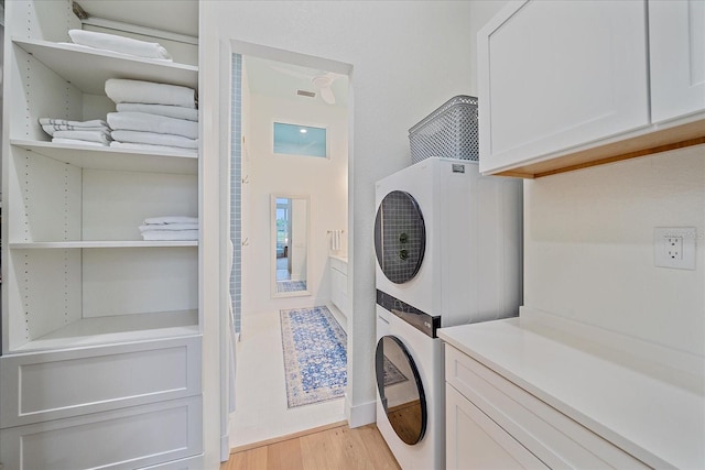 7507 Ascot Ct, University Park, FL 34201 - laundry room with cabinet space, stacked washer / drying machine, and light wood-style floors