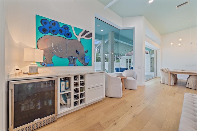 7507 Ascot Ct, University Park, FL 34201 - bar area with beverage cooler, light wood-style flooring, and a chandelier