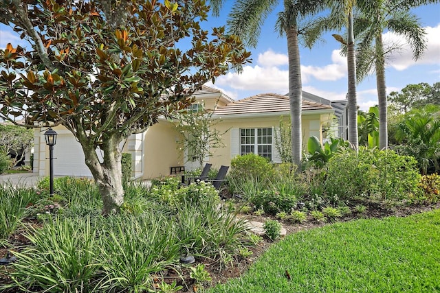 7507 Ascot Ct, University Park, FL 34201 - view of property exterior featuring a tiled roof, stucco siding, an attached garage, and driveway