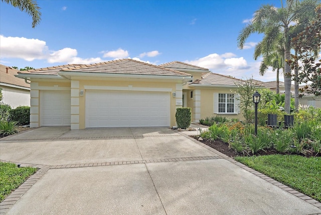 7507 Ascot Ct, University Park, FL 34201 - view of front of home with a garage, concrete driveway, a tile roof, and stucco siding