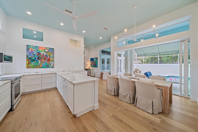 7507 Ascot Ct, University Park, FL 34201 - kitchen with electric stove, a peninsula, light wood-type flooring, ceiling fan, and light stone counters