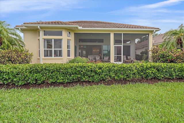 7507 Ascot Ct, University Park, FL 34201 - back of property with stucco siding, a lawn, and a sunroom