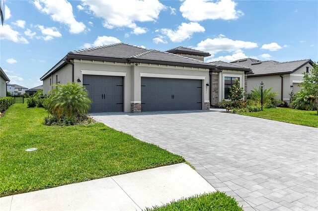 4971 Oyster Pearl St, Bradenton, FL 34211 - prairie-style home with a front yard, a garage, decorative driveway, and stucco siding