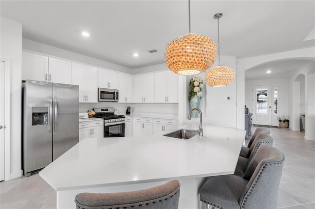 4971 Oyster Pearl St, Bradenton, FL 34211 - kitchen with appliances with stainless steel finishes, a sink, arched walkways, light countertops, and a breakfast bar